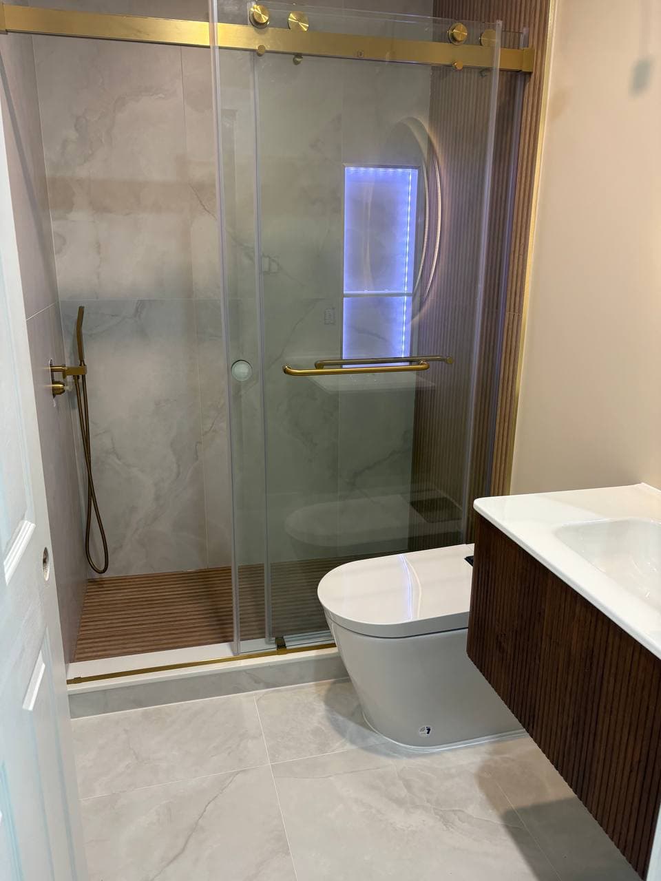 Full bathroom remodel with glass shower door and floating vanity
