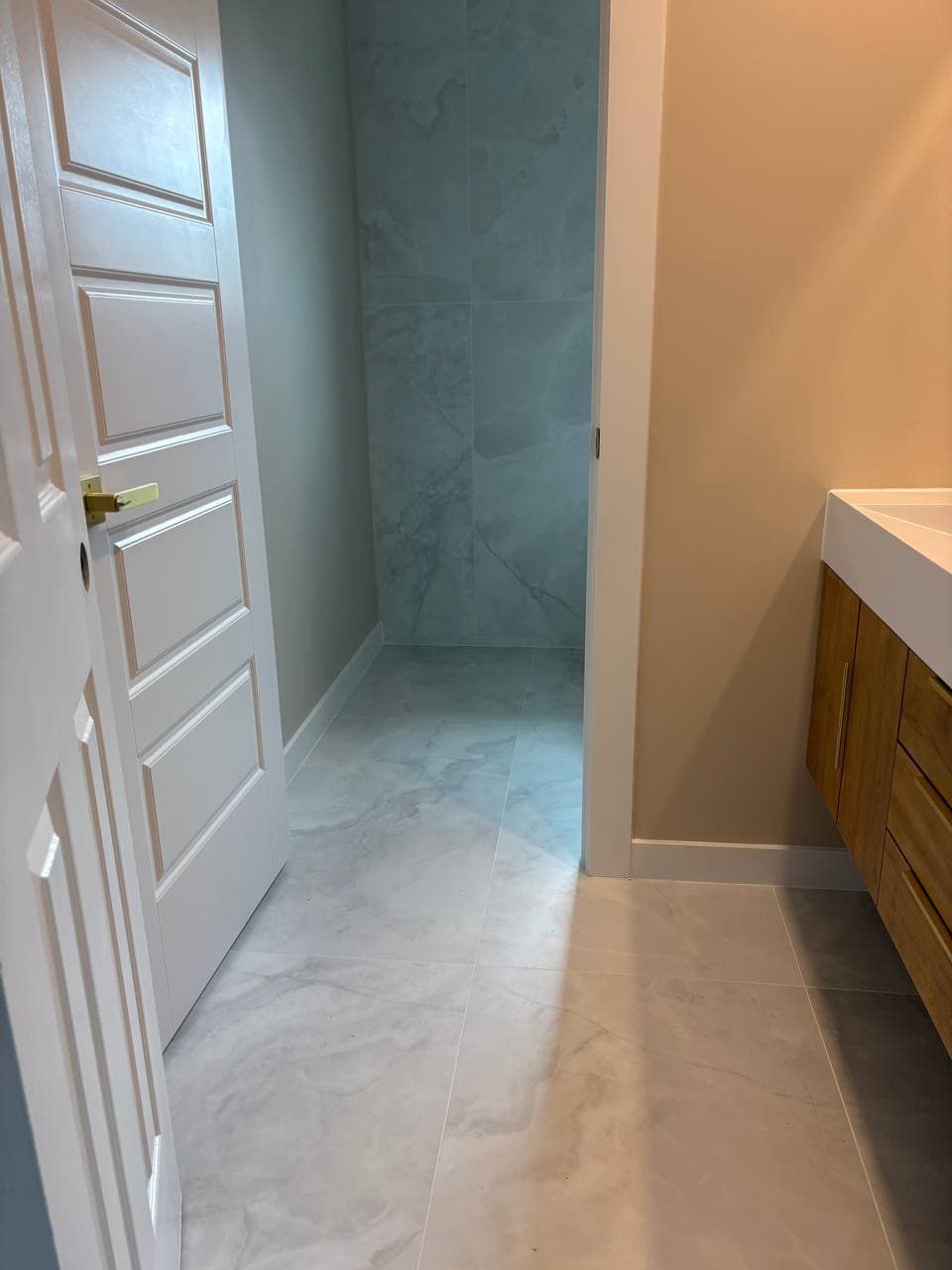 Seamless marble floor tiles flowing from hallway into bathroom