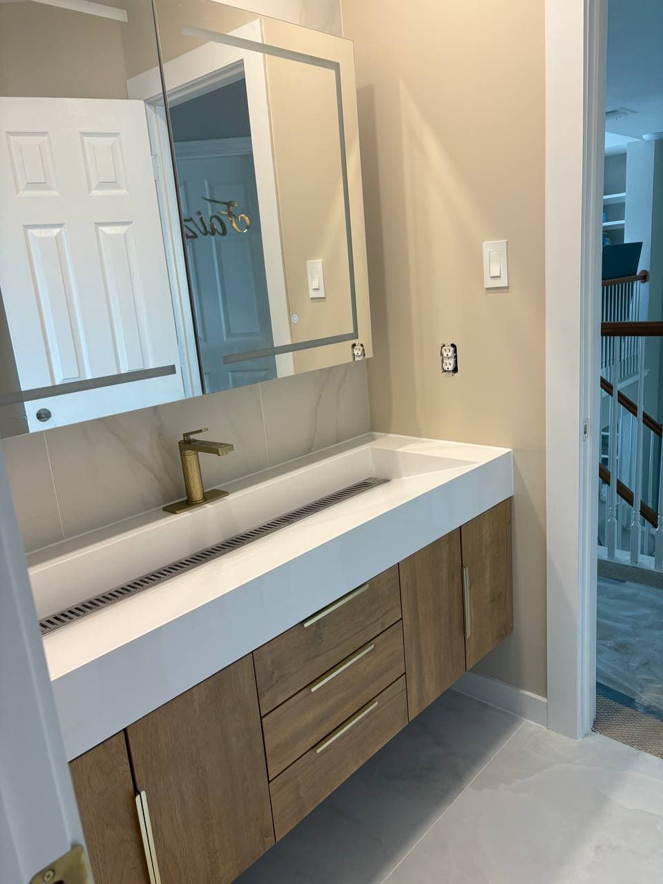 Floating wood vanity with trough sink in McKinney TX bathroom remodel